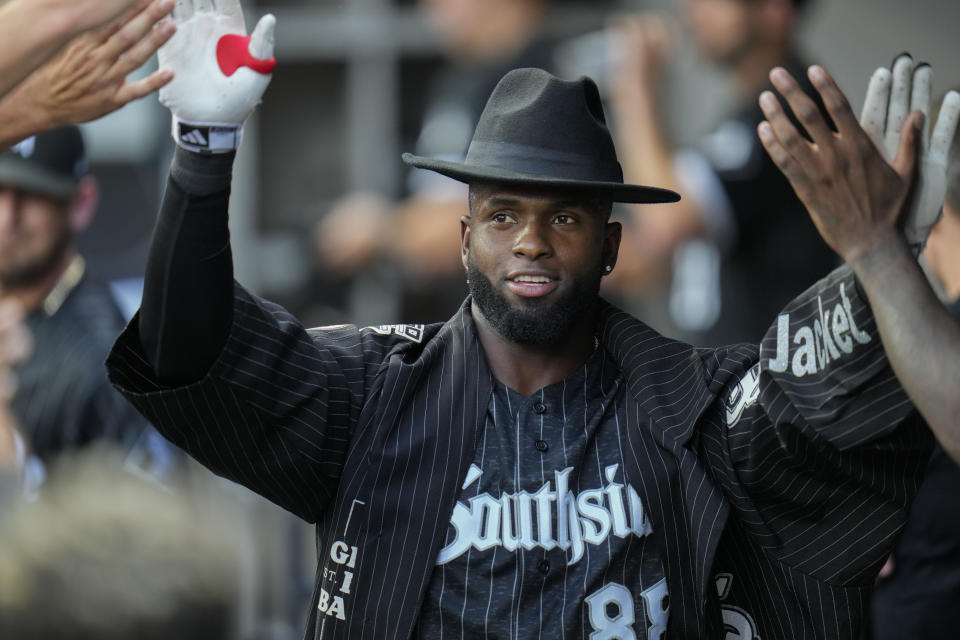 Wearing the home run cape and fedora, Chicago White Sox's Luis Robert Jr. celebrates in the dugout after hitting a home run during the first inning of a baseball game against the Cleveland Guardians, Friday, July 28, 2023, in Chicago. (AP Photo/Erin Hooley)