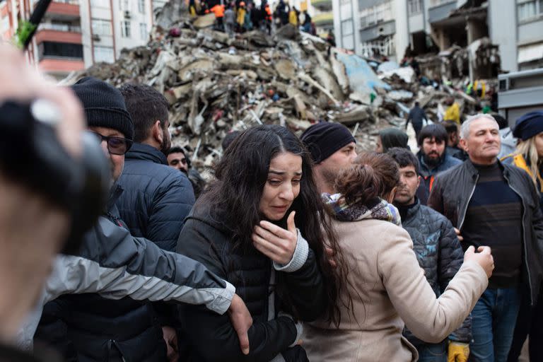 Una mujer reacciona mientras los rescatistas buscan sobrevivientes entre los escombros de los edificios derrumbados en Adana, el 6 de febrero de 2023