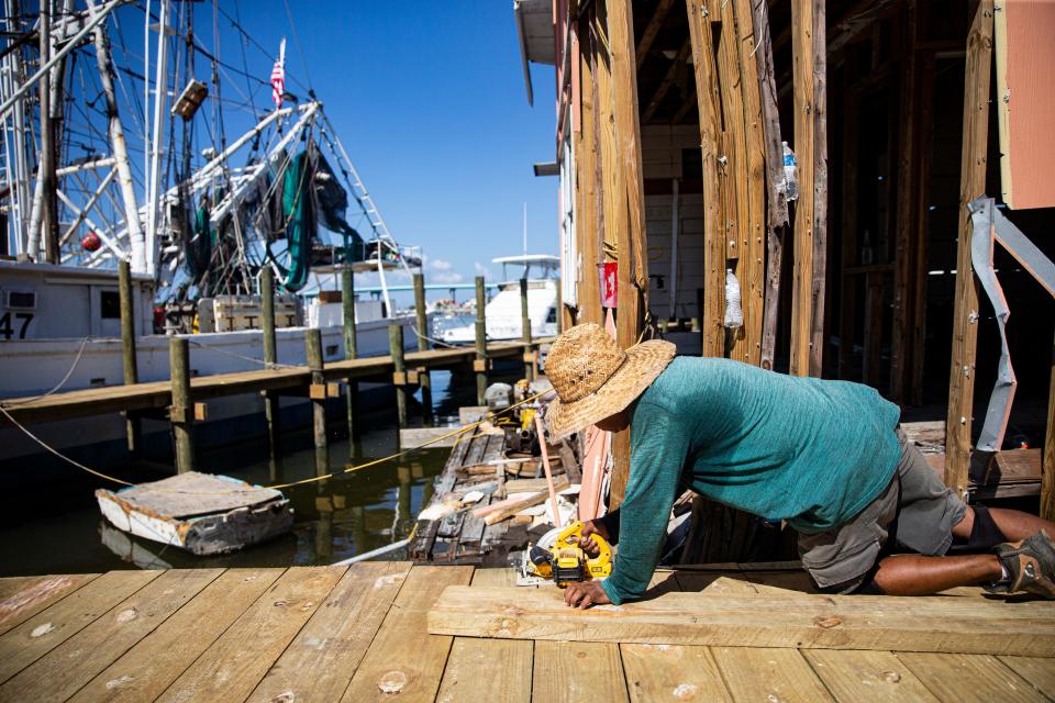 Marcos Galindo builds a dock at Erickson & Jensen Shrimp Packers on San Carlos Island on Fort Myers Beach on Wednesday, Sept. 13, 2023. Nearly a year after Hurricane Ian tossed most of the shrimp boats ashore, Erickson & Jensen is surviving but struggling. High fuel prices and low shrimp prices are not helping as they rebuild docks and buildings. The hope for the future includes building a working waterfront that would be called "Shrimp Town." This would include a restaurant and market.