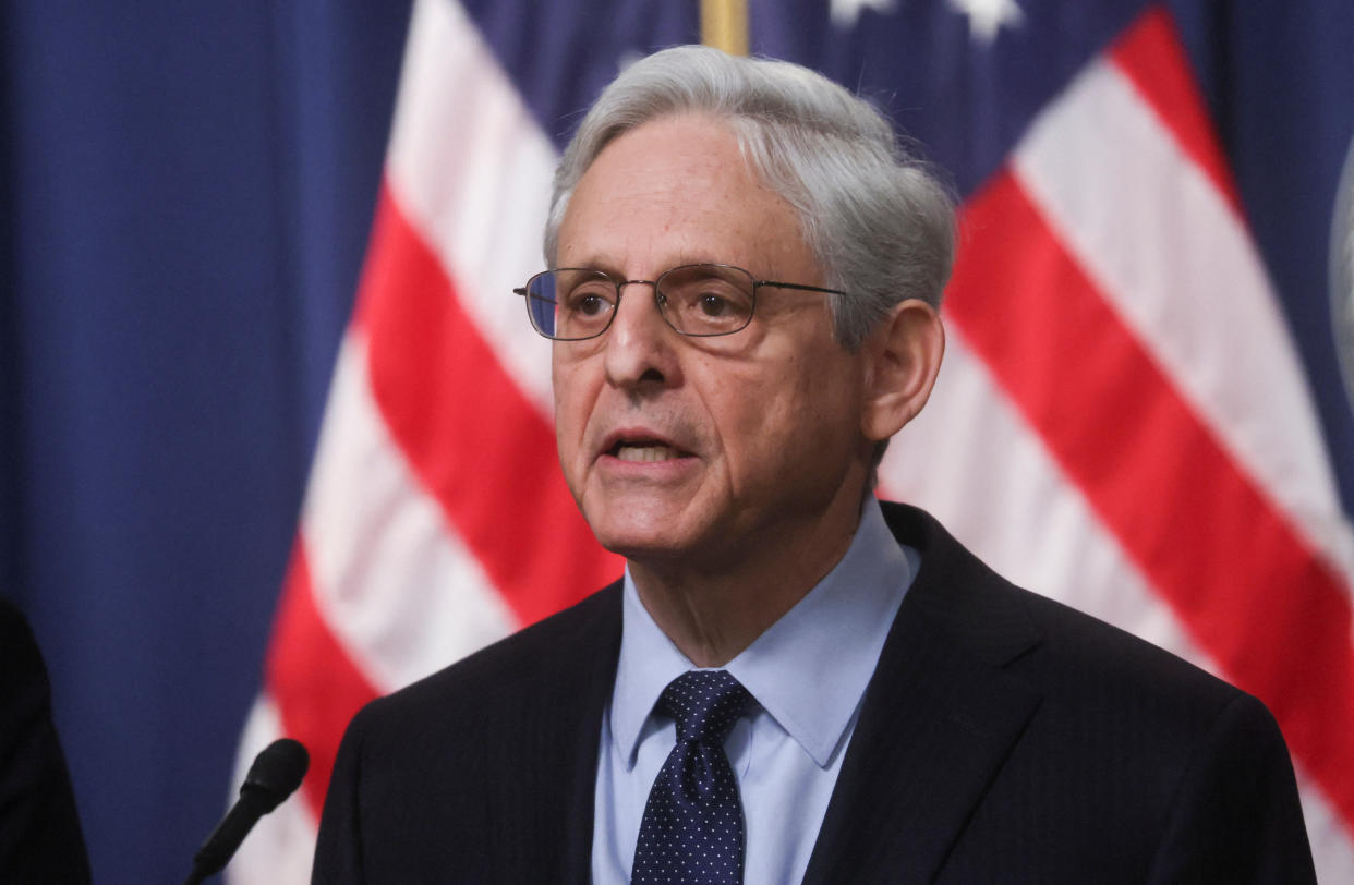 Merrick Garland speaks in front of an American flag.