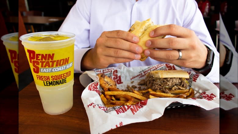 man holding penn station sub