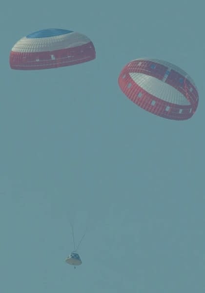 cone-shaped spacecraft landing under two parachutes