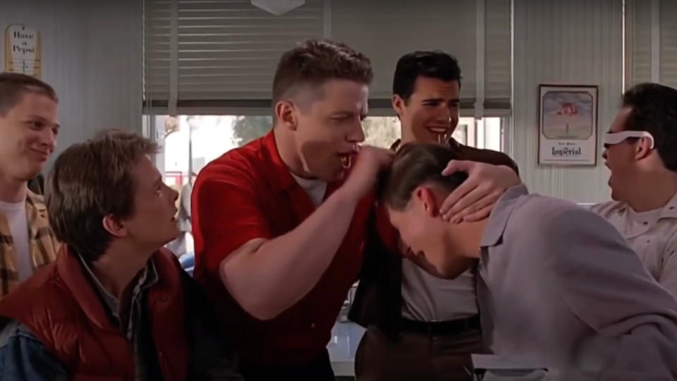 Thomas F Wilson knocks on Crispin Glover's head in front of Michael J Fox in Back To The Future.