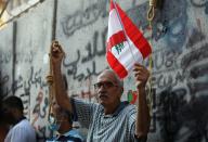A man carries a flag and a noose during a demonstration in Beirut
