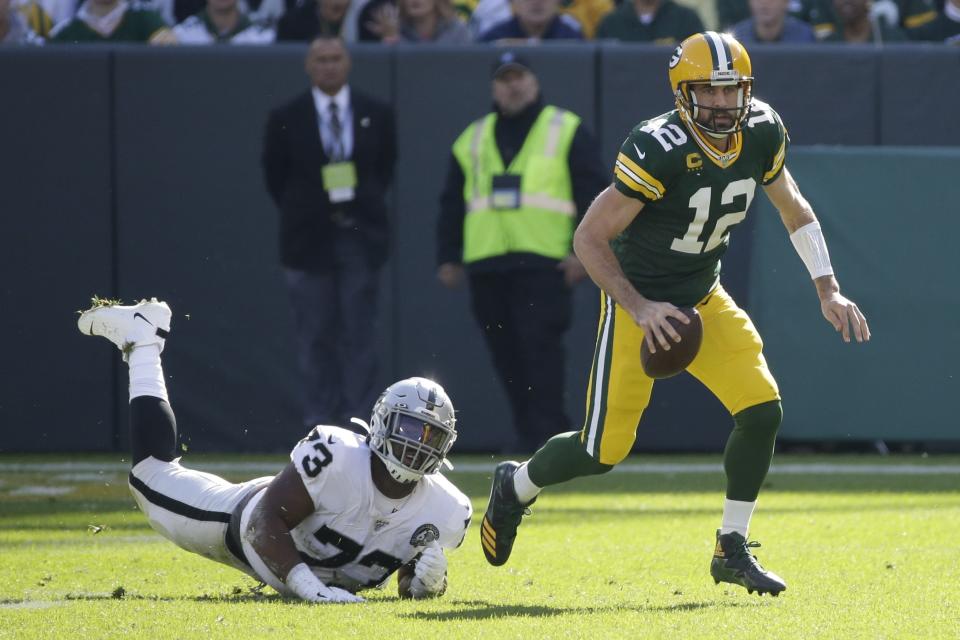 Green Bay Packers' Aaron Rodgers gets away from Oakland Raiders' Maurice Hurst during the first half of an NFL football game Sunday, Oct. 20, 2019, in Green Bay, Wis. (AP Photo/Mike Roemer)