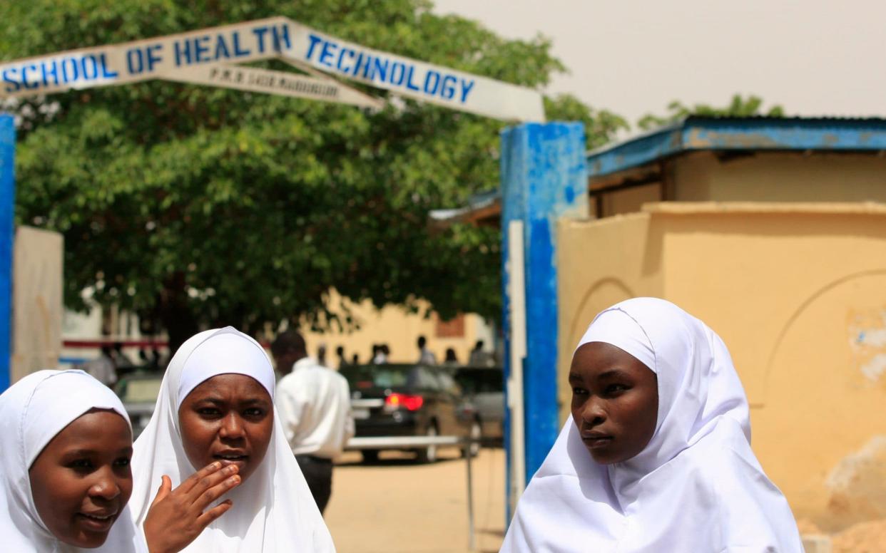 Young women stand in front of a school in Maiduguri. The 2014 kidnappings in neighbouring Borno state brought Boko Haram international attention - AP