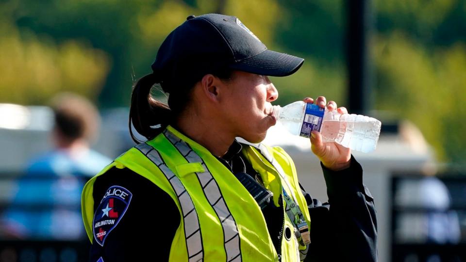 PHOTO: In this Aug. 19, 2023, file photo, a police officer directing traffic takes a break to drink water during a record-breaking heat wave, in Arlington, Texas. (Lm Otero/AP, FILE)