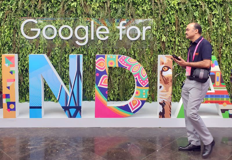 FILE PHOTO: A man walks past the sign of "Google for India", the company's annual technology event in New Delhi