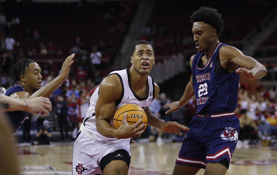 San Diego State forward Jaedon LeDee drives against Fresno State's Leo Colimerio, right, during the first half of an NCAA college basketball game in Fresno, Calif., Saturday, Feb. 24, 2024. (AP Photo/Gary Kazanjian)