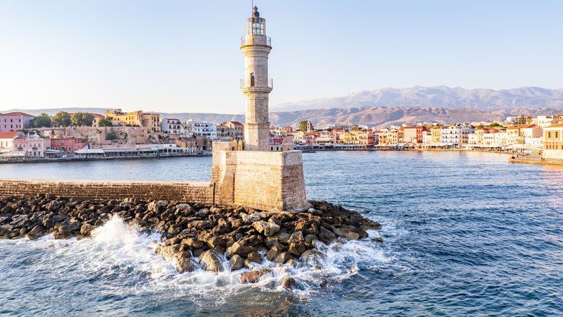 waves crashing on lighthouse, chania, crete, greece