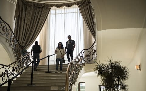 Visitors walk down a foyer in the Miguel Aleman house at Los Pinos, the former official residence of the President of Mexico, in Mexico City - Credit: Bloomberg