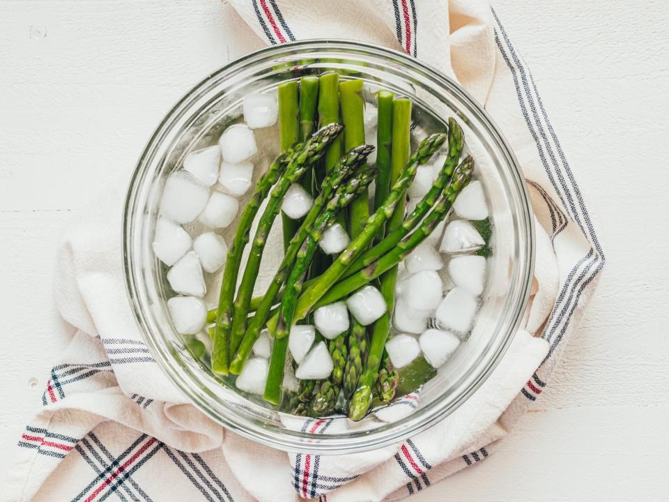asparagus spears in a bowl of ice water