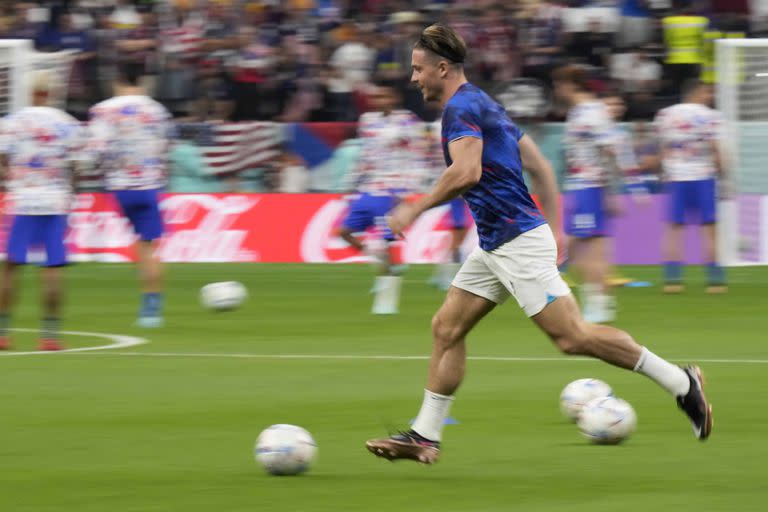 England's Jack Grealish runs with a ball during warmup before the World Cup group B soccer match between England and The United States, at the Al Bayt Stadium in Al Khor , Qatar, Friday, Nov. 25, 2022. (AP Photo/Luca Bruno)