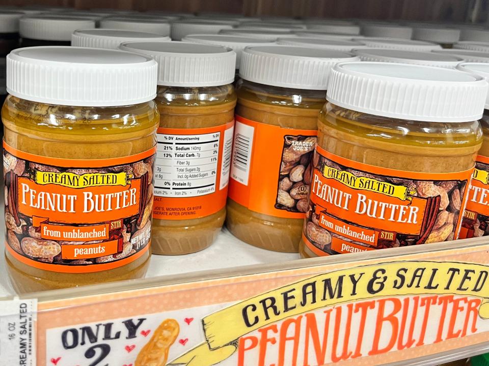 Jars of Trader Joe's creamy salted peanut butter on a shelf.