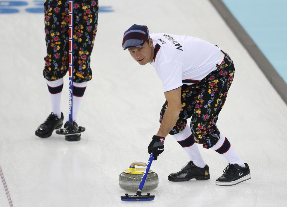 Norway skip Thomas Ulsrud, wearing rose-painting knickers and a patterned flat cap, sweeps ahead of the stone during curling training at the 2014 Winter Olympics, Saturday, Feb. 8, 2014, in Sochi, Russia. (AP Photo/Robert F. Bukaty)