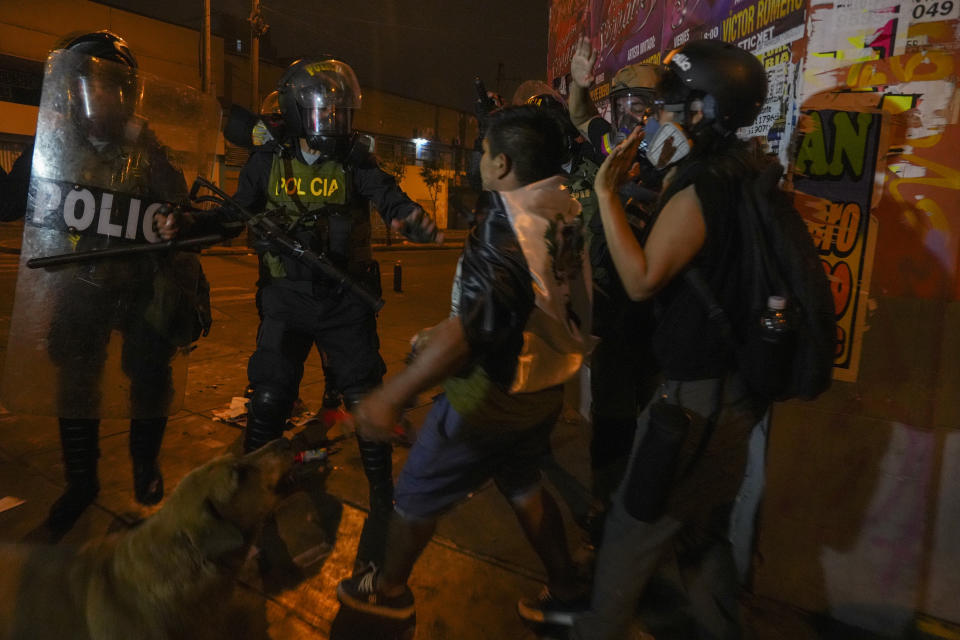 Police corner protesters during and anti-government march in Lima, Peru, Friday, Jan. 20, 2023. Protesters are seeking the resignation of President Dina Boluarte, the release from prison of ousted President Pedro Castillo and immediate elections. (AP Photo/Guadalupe Pardo)