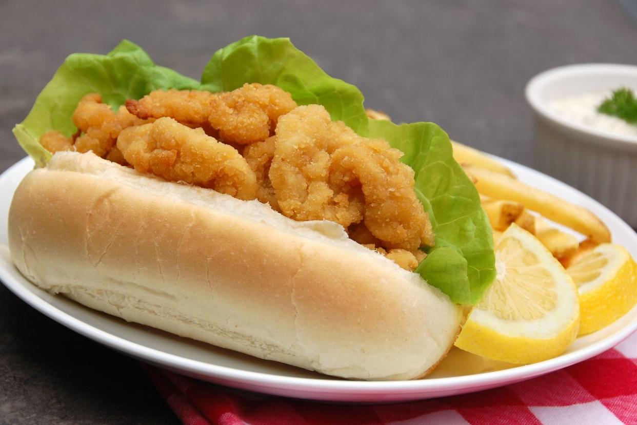 A traditional New England summer lunch: fried clams on a hot-dog roll served with tartar sauce and french fries