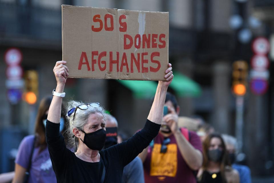 A woman holds up a sign reading "SOS Afghan women" as she attends a demonstration called by "Ca la Dona" feminist association in support of Afghan women and girls, in Barcelona on Wednesday.