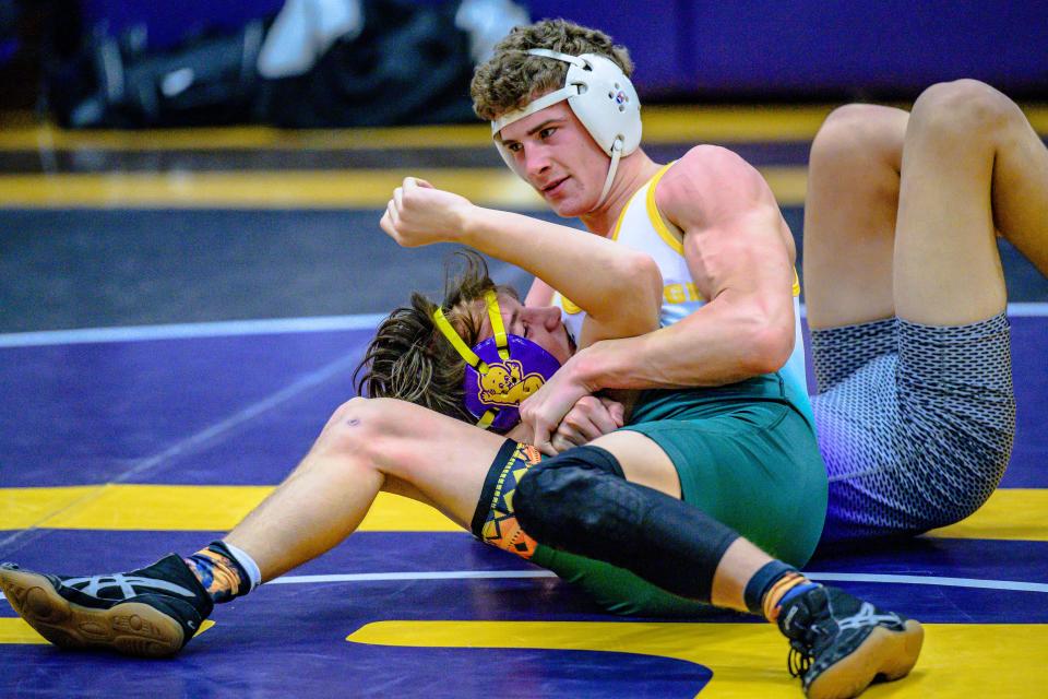Rock Bridge's Carter McCallister forces Hickman's Ayden Hanft into a headlock before getting the pin on January 3, 2022, at Hickman High School.