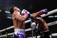Gervonta Davis, right, knocks down Rolando Romero during the sixth round of a WBA lightweight championship boxing bout early Sunday, May 29, 2022, in New York. Davis stopped Romero in the sixth round. (AP Photo/Frank Franklin II)
