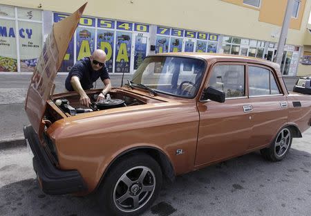 Lester Luis checks a Moskvich in front of Fabian Zakharov's Zakharov Auto Parts shop in Hialeah, Florida, February 4, 2015. REUTERS/Javier Galeano