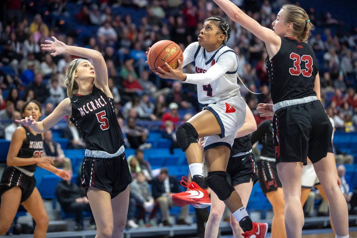 Sacred Heart’s Triniti Ralston (4) shoots the ball as McCracken County’s Briley Benton (5) and Mikee Buchanan (33) defend during the Girls’ Sweet 16 championship game at Rupp Arena.
