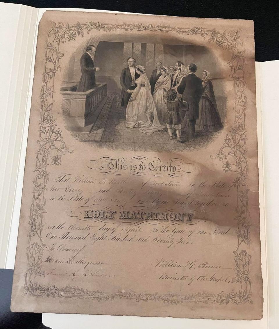 The marriage certificate of William DeWorth and Katey Havey as well as the photo that the certificate was discovered hidden in the back of.