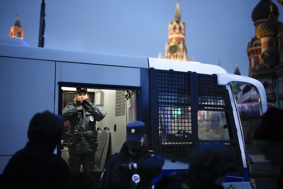 FILE - A police officer stands inside a police bus with detained demonstrators during am antiwar protest near Red Square with St. Basil's Cathedral, right, in the background in Moscow, Russia, on Sept. 24, 2022. Putin signs a law that calls for up to 15 years in prison for spreading false or defamatory information about the military. (AP Photo, File)