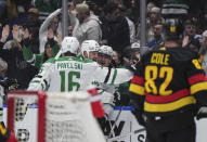 Dallas Stars' Roope Hintz (24), Jamie Benn (14) and Joe Pavelski (16) celebrate Hintz's goal against the Vancouver Canucks during the first period of an NHL hockey game Thursday, March 28, 2024, in Vancouver, British Columbia. (Darryl Dyck/The Canadian Press via AP)