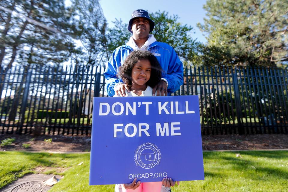 Paris Powell and his daughter, Cassidy, stand with other demonstrators in front of the Governor's Mansion on Thursday as they protest the execution of death row inmate Michael DeWayne Smith.
