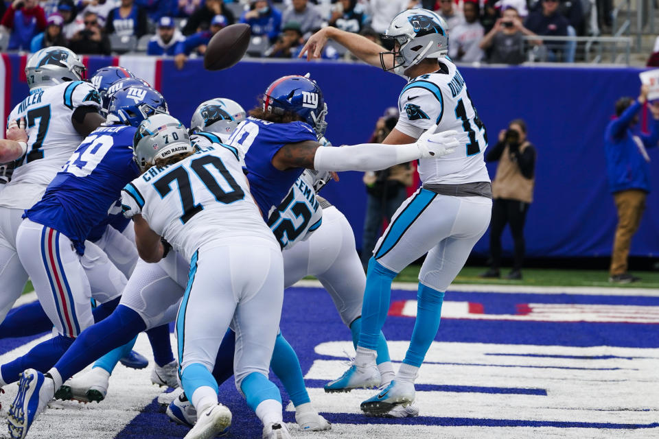 Carolina Panthers quarterback Sam Darnold (14) throws a pass as he is hit by New York Giants' Leonard Williams (99) during the first half of an NFL football game, Sunday, Oct. 24, 2021, in East Rutherford, N.J. The play was ruled intentional grounding in the end zone, resulting in a safety. (AP Photo/Seth Wenig)