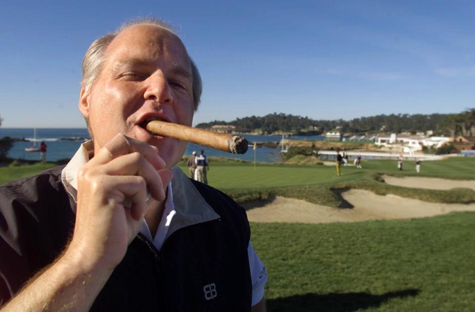 FILE - In this Feb. 3, 2001, file photo, Rush Limbaugh puffs on his Ashton VSG cigar while waiting to tee off from the fifth tee of the Pebble Beach Golf Links during third round play of the AT&T Pebble Beach National Pro-Am in Pebble Beach, Calif. Limbaugh, the talk radio host who became the voice of American conservatism, has died. His death Wednesday, Feb. 17, 2021, at the age of 70 was announced on his website. (AP Photo/Eric Risberg, File)