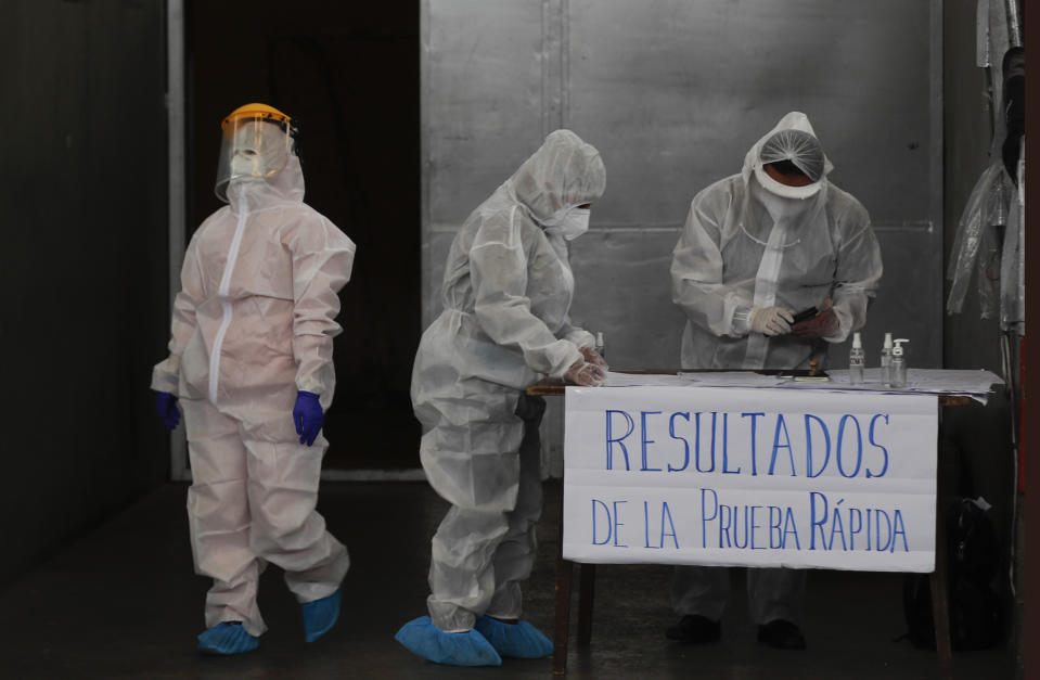 Trabajadores de la salud se preparan para realizar una prueba de coronavirus en una instalación deportiva en La Paz, Bolivia, el viernes 8 de enero de 2021. (AP Foto/Juan Karita)