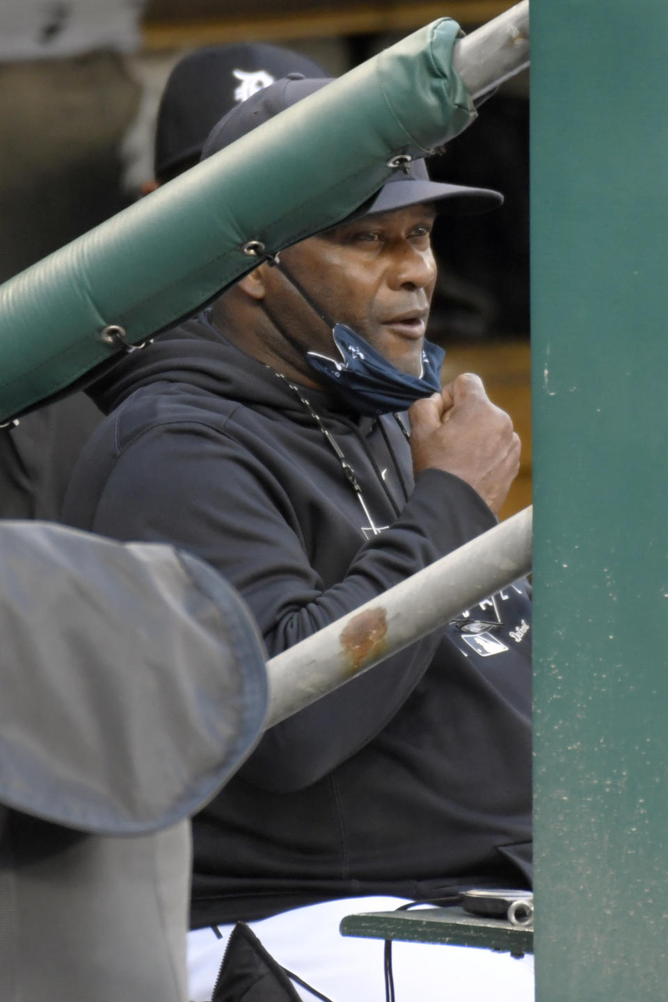 Detroit Tigers manager Lloyd McClendon takes off his face mask to eat a snack in the first inning of a baseball game against the Cleveland Indians, Saturday, Sept. 19, 2020, in Detroit. McClendon is now the manager of the Tigers after Ron Gardenhire announced his retirement earlier in the day. (AP Photo/Jose Juarez)