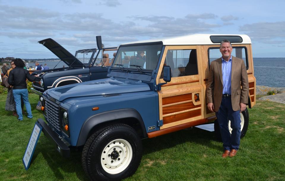 Jeff Taylor poses with his 'woodie' electric 1991 Land Rover Defender 90 after having a conversation with Jay Leno about the one-of-a-kind vehicle at The Gathering at Rough Point.