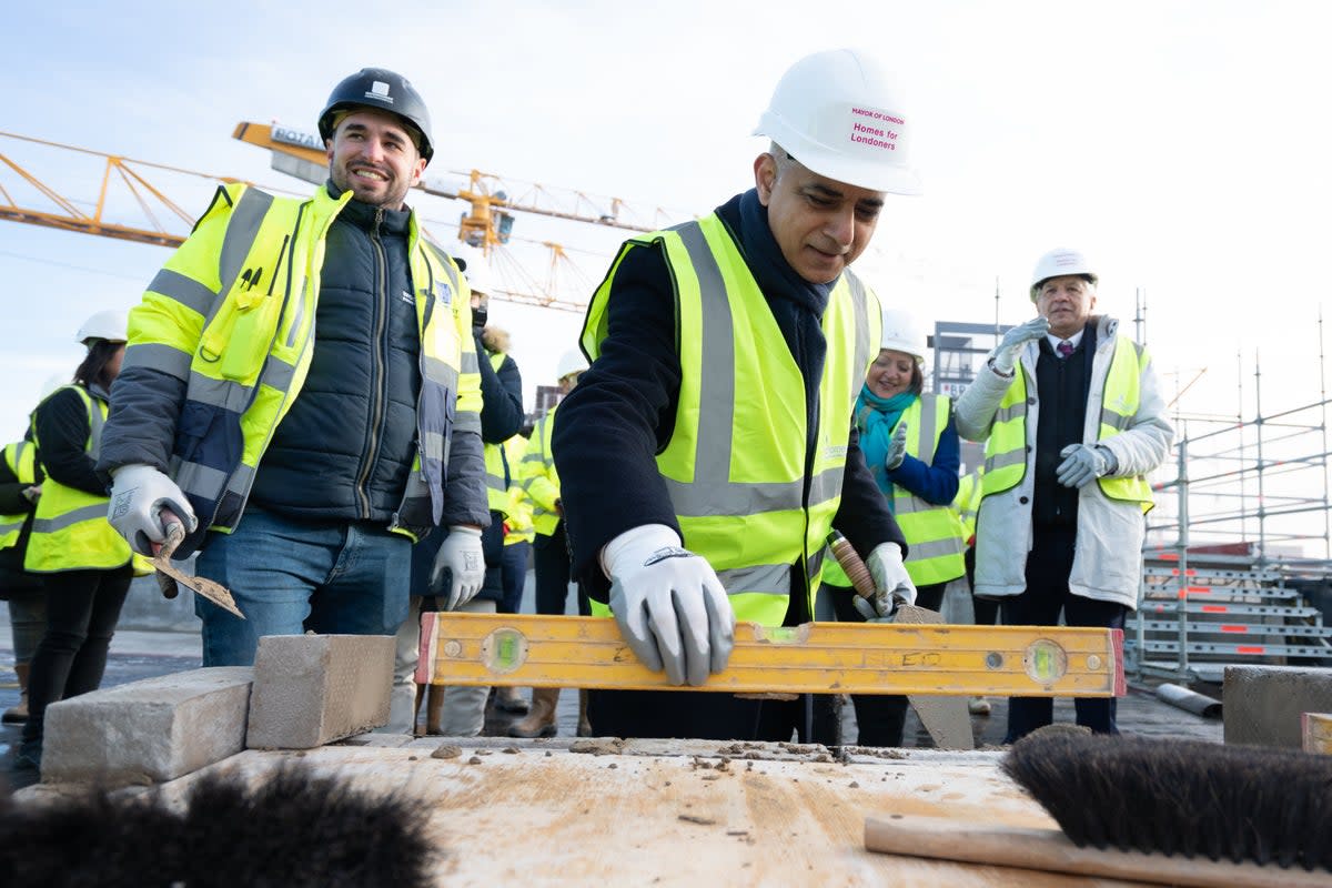 Mayor of London Sadiq Khan, pictured trying his hand at bricklaying at a new affordable housing development in the Royal Docks in January 2023 (PA)