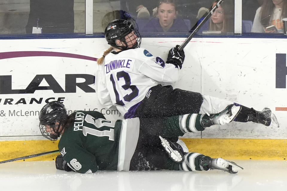 Boston forward Amanda Pelkey (16) and Minnesota forward Grace Zumwinkle (13) crash into the boards during the third period in Game 1 of a PWHL hockey championship series Sunday, May 19, 2024, in Lowell, Mass. (AP Photo/Steven Senne)