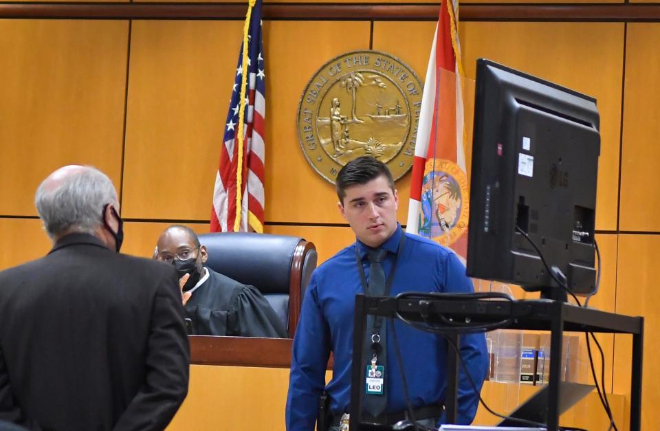 Titusville Police Detective Parker Landis looks over photos shown during a bond hearing for Lakeisha Mitchell. He had questioned Mitchell's statements about leaving 4-year-old Joy King-Castro alone in a bathtub while she was unconscious. "What did you think was going to happen?" he asked her during a recorded interview played in court.