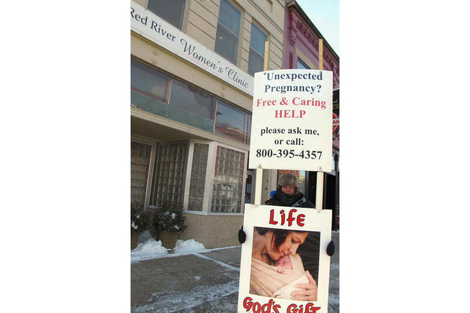 FILE - In this Feb. 20, 2013 file photo, an abortion protester stands outside the Red River Valley Women's Clinic in Fargo, N.D. North Dakota's sole abortion clinic filed a federal lawsuit Tuesday, June, 24, 2019, over two state laws it believes forces doctors to lie, including one measure passed this year requiring physicians to tell women that they may reverse a so-called medication abortion if they have second thoughts. The complaint from the Center for Reproductive Rights on behalf of the Red River Women's Clinic. (AP Photo/Dave Kolpack, File)