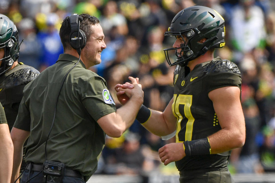 Oregon head coach Dan Lanning greets Oregon quarterback Bo Nix (10) after a touchdown against BYU during the first half of an NCAA college football game, Saturday, Sept. 17, 2022, in Eugene, Ore. (AP Photo/Andy Nelson)