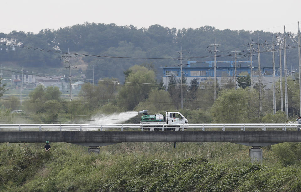 Disinfectant solution is sprayed from a vehicle as a precaution against African swine fever near a pig farm in Paju, South Korea, Tuesday, Sept. 17, 2019. South Korea is culling thousands of pigs after confirming African swine fever at a farm near its border with North Korea, which had an outbreak in May. (AP Photo/Ahn Young-joon)