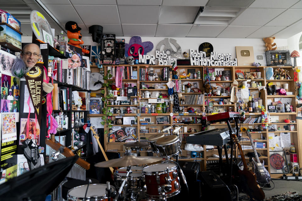 An assortment of knickknacks, stickers, albums and other collectables can be seen on this shelf that serves as the background for NPR's Tiny Desk concert series, pictured on Wednesday, Aug. 30, 2023, in Washington. (AP Photo/Stephanie Scarbrough)