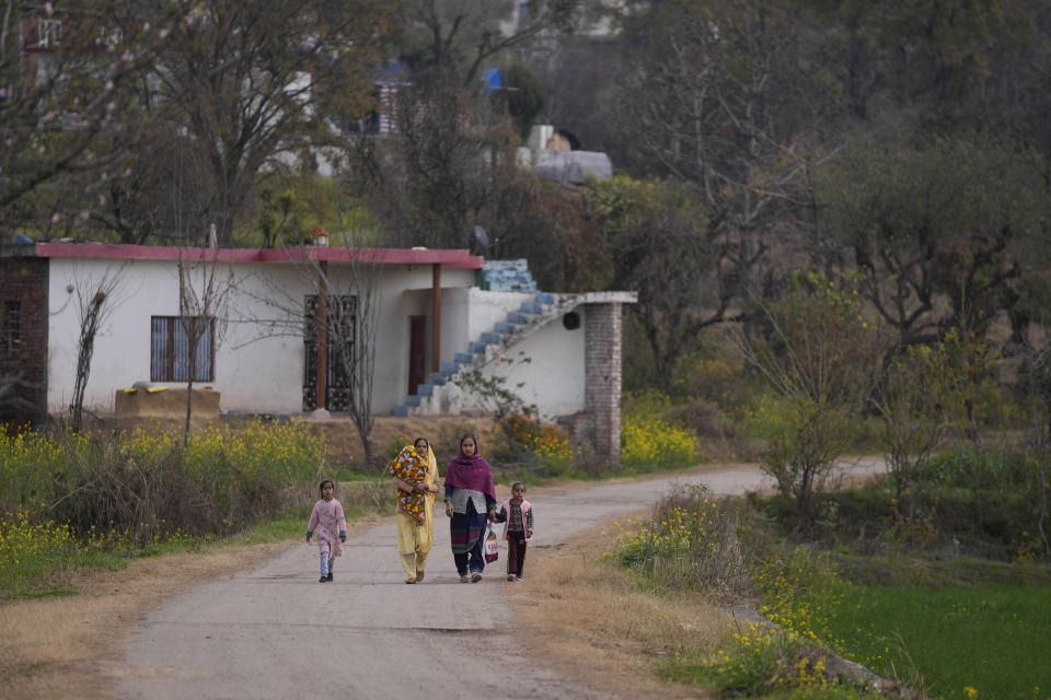 Villagers walk towards the market at Dhangri Village, where seven Hindus were killed in early January in two back-to-back attacks, frontier Rajouri district, Indian controlled Kashmir, Feb. 8, 2023. Days after the deadly violence, Indian authorities revived a government-sponsored militia and began rearming and training thousands of villagers, including some teenagers. The militia, officially called the “Village Defense Group,” was initially formed in the 1990s as the first line of defense against anti-India insurgents in remote villages that government forces could not reach quickly. (AP Photo/Channi Anand)