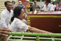 Mother of Son Sophat, a teen victim of a boat accident, cries by her daughter's coffin during a funeral procession in Koh Chamroeun village, east of Phnom Penh, Cambodia, Friday, Oct. 14, 2022. Multiple students in southern Cambodia who were crossing a river have died after the boat they were on capsized Thursday night, officials said. (AP Photo/Heng Sinith)