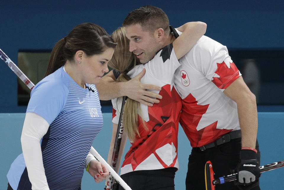 <p>Canada’s Kaitlyn Lawes, center, and John Morris, right, embrace as United States Becca Hamilton passes by after their mixed doubles curling match at the 2018 Winter Olympics in Gangneung, South Korea, Thursday, Feb. 8, 2018. (AP Photo/Aaron Favila) </p>