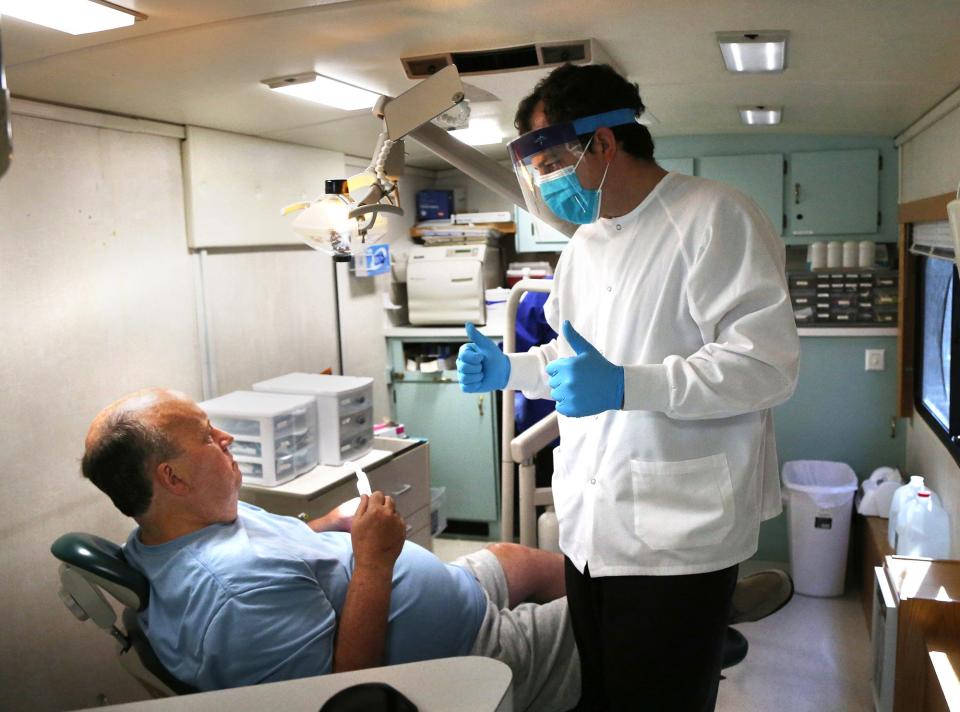 Ed Ferrick from North Hampton is 61 and has had dentures for 15 years put in by Tufts Dental School. He needed them to be filed down due to an unbearable irritation. DMD Brian Cicero gives thumbs up to Ed after he says it feels like a good adjustment to him. Dentists and hygenists come to the van parked at St. Vincent De Paul food pantry in Exeter.