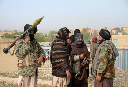 FILE PHOTO - Members of the Taliban gather at the site of the execution of three men accused of murdering a couple during a robbery in Ghazni province, Afghanistan April 18, 2015. REUTERS/Stringer/File Photo