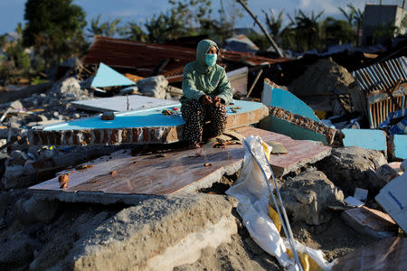 Hesti Andayani, 27, sits on a pile of tiles that she says used to be part of her second-floor bedroom after her home was destroyed by an earthquake, in Balaroa neighbourhood, Palu, Central Sulawesi, Indonesia, October 10, 2018. REUTERS/Jorge Silva