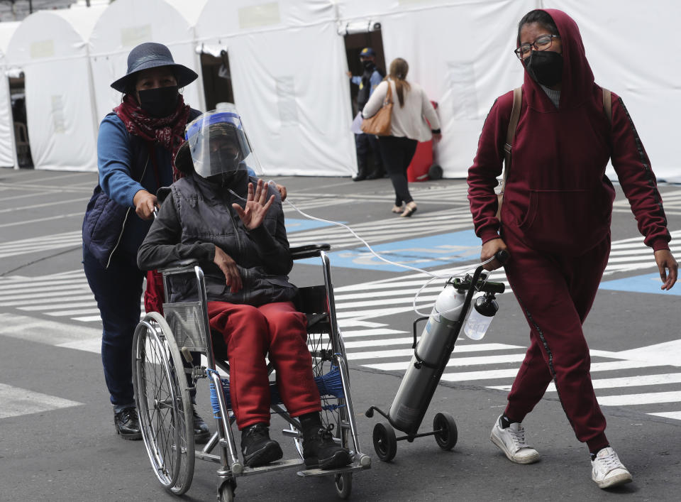 Una mujer diagnosticada con COVID-19 ingresa al hospital del Instituto del Seguro Social acompañada de familiares en Quito, Ecuador, el martes 19 de enero de 2021. (AP Foto/Dolores Ochoa)