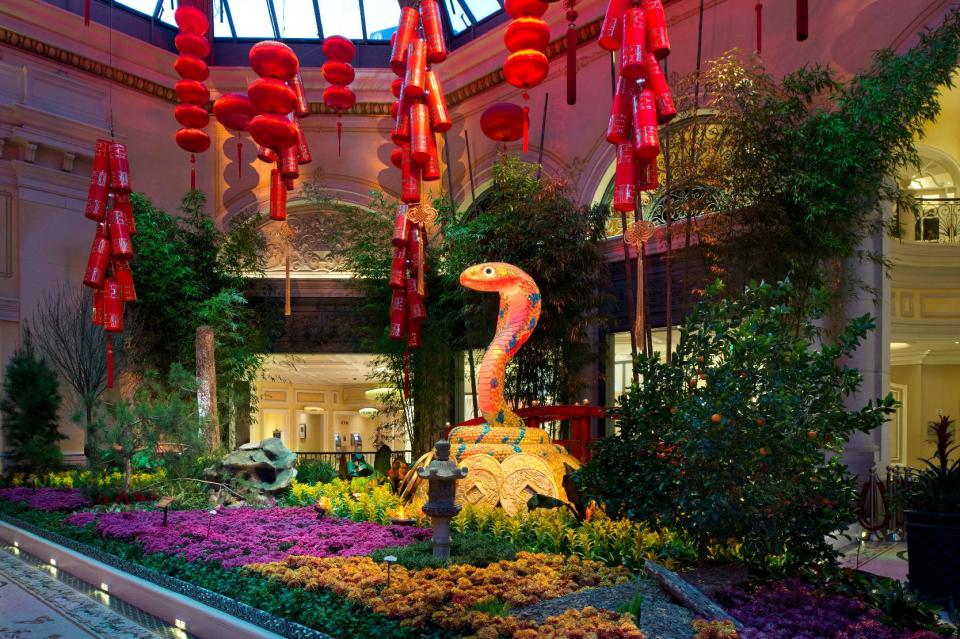 This January 2013 photo provided by MGM Resorts International shows the Chinese New Year floral display at the Bellagio Conservatory & Botanical Gardens in Las Vegas welcoming the year of the snake. The display includes a money tree decorated with gold coins, red lanterns, a 9-foot snake, a waterfall and wooden boat. It’s one of a number of exhibits and events around Las Vegas marking the year of the snake, which begins on Feb. 10. (AP Photo/MGM Resorts International)